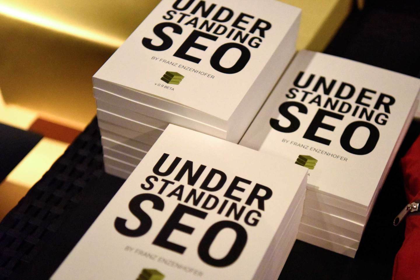 A stack of printed copies of Understanding SEO by Franz Enzenhofer